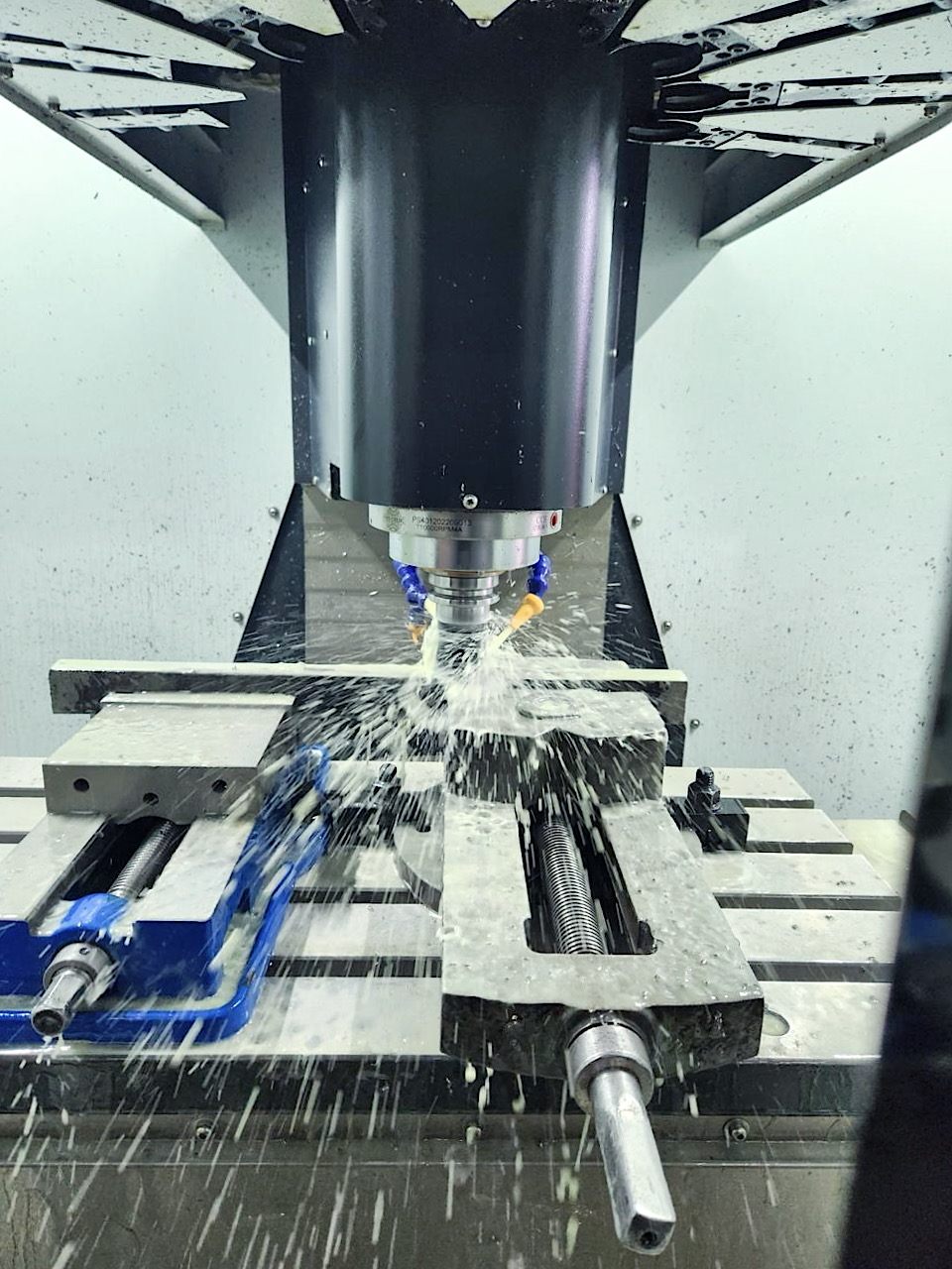 Centro de maquinado CNC trabajando con refrigerante
